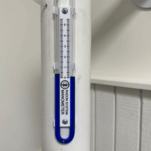 Radon system manometer on pipe inside of home