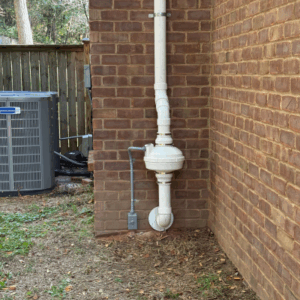 Radon mitigation system installed on brick house