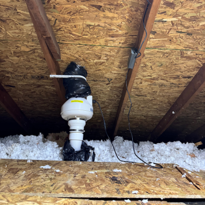 Pipe and fan in attic of a home to vent it safely outside.
